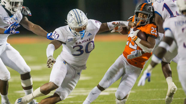 Oct 30, 2021; Stillwater, Oklahoma, USA; Kansas Jayhawks linebacker Rich Miller (30) tackles Oklahoma State Cowboys running back Jaden Nixon (23) during the third quarter at Boone Pickens Stadium. Oklahoma State won 55-3. Mandatory Credit: Brett Rojo-USA TODAY Sports
